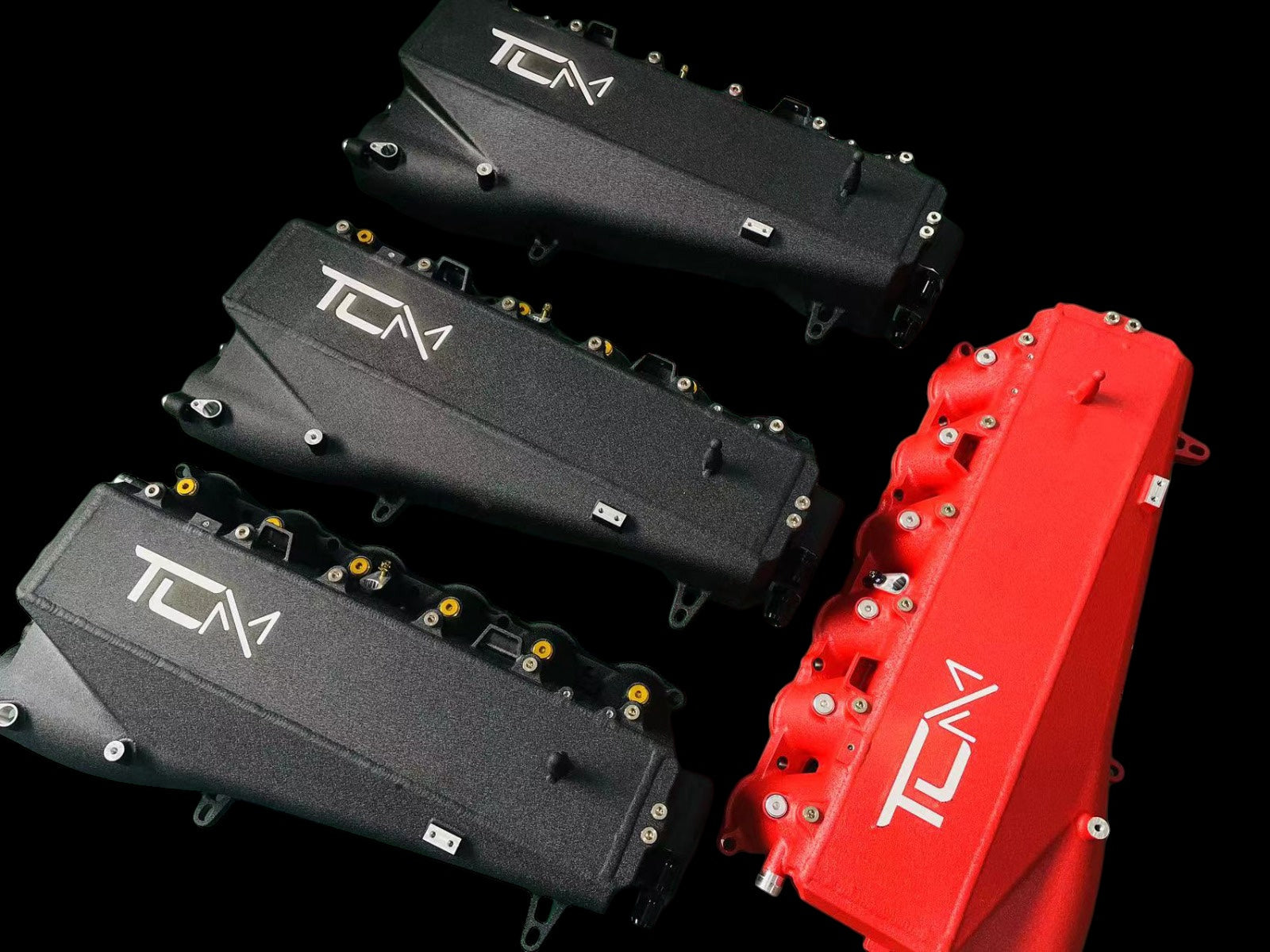 TCM branded engine covers in black and red on a black background